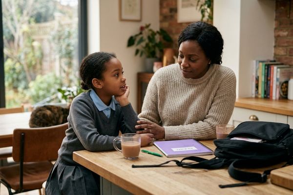 Black parent listening to child after school during a supportive conversation at home Racism in UK Schools