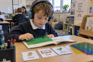 A child using coloured overlays and visual aids at a school desk, supported learning tools in a calm classroom
